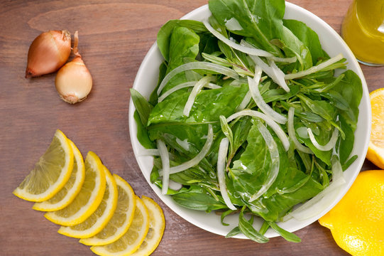Rucola salad leaves with ingredients on a wooden plate
