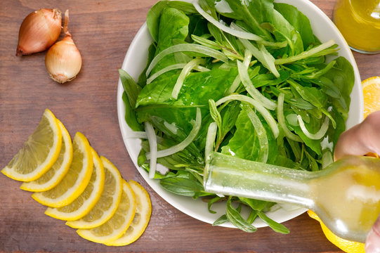 Rucola salad leaves with ingredients on a wooden plate