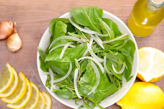 Rucola salad leaves with ingredients on a wooden plate