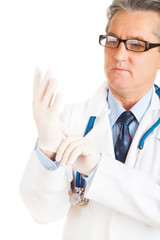 Male doctor putting on protective gloves on white background
