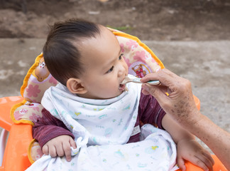 mother feeding  baby eating food by spoon