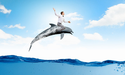 Man saddling dolphin © Sergey Nivens