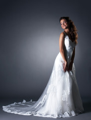 Fototapeta na wymiar Happy bride posing in elegant wedding dress