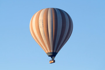 A hot air balloon flying on a clear sky day.
