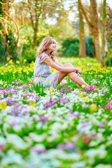 Naklejka na ściany i meble Happy young girl sitting on the grass