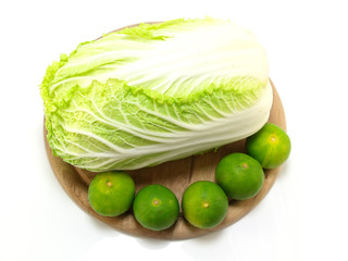 fresh green cabbage and lime on wooden chopping board