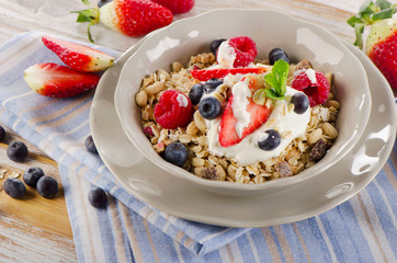 Breakfast with fresh berries, yogurt and  muesli.