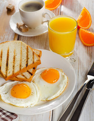 breakfast with fried eggs, toasts, juice and coffee