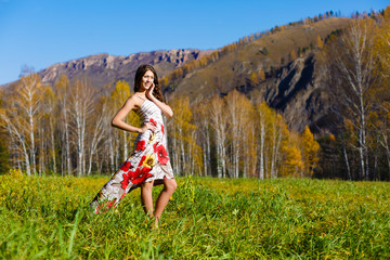 happy young woman in the autumn wood of the mountain