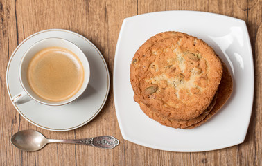 Top view on cup of coffee and plate with cookies