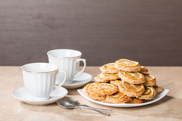 cups of tea with almond biscuits with lemon