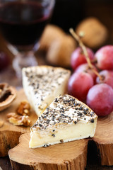 White mold French cheese like Brie with grapes and walnuts