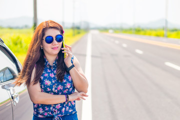 Business woman at roadside is using her mobile phone to communic