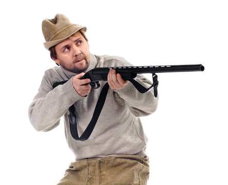 hunter in hat takes aim from a gun