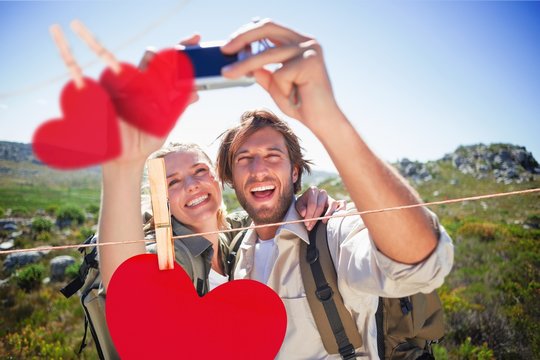 Hking couple standing on mountain terrain taking a selfie