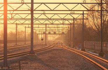 Empty railroad tracks during sunrise.