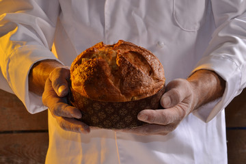 Panadero sujetando panettone recién horneado.