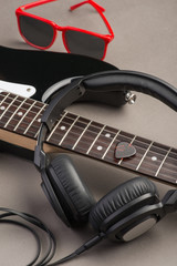 Black guitar with headphones and red sunglasses