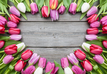 tulips arranged on old wooden background - obrazy, fototapety, plakaty
