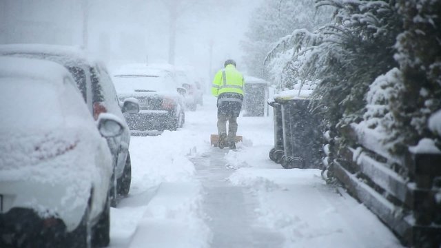 Mann r&auml;umt Gehweg von Schnee frei