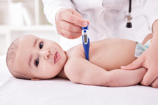 Pediatrician measure the temperature of the baby