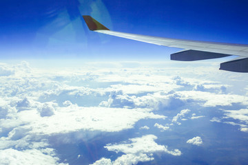 Wing of an airplane in beautiful sky with clouds