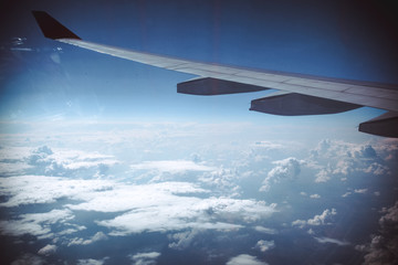Obraz premium Wing of an airplane in beautiful sky with clouds