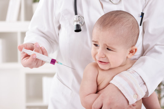 Craying little baby boy receive vaccine