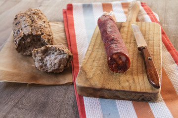 Spanish sausage with bread over a wooden table