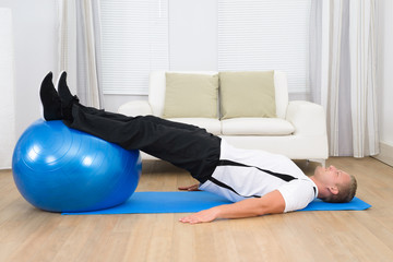 Man Exercising On A Pilates Ball