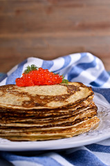 A stack of pancakes with red caviar