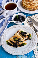 A stack of pancakes with black caviar