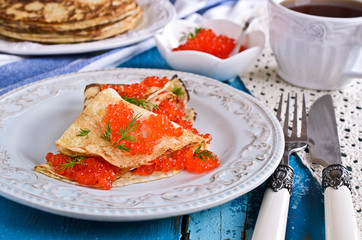 A stack of pancakes with red caviar
