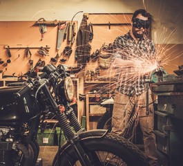 Mechanic doing lathe works in motorcycle customs garage