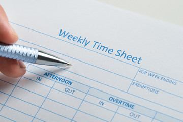 Person Hand With Pen Over Weekly Time Sheet