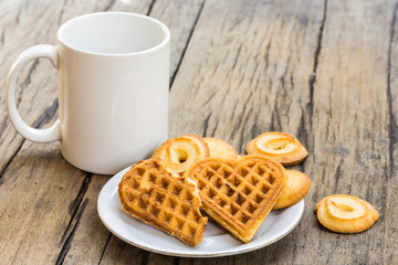 waffles heart shaped and cookie on white plate and coffee cup