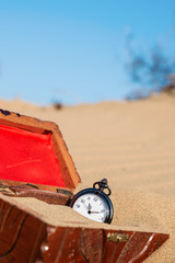 Pocket watch buried in sand