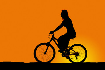 silhouette of a woman riding a bike