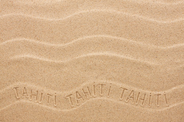 Fototapeta na wymiar Tahiti inscription on the wavy sand