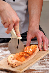 Preparando y cortando calzone,pizza.