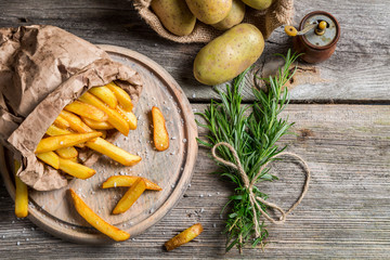 Homemade fries with salt served in paper