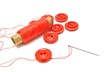spool of red thread and buttons
