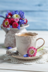 Cup of hot coffee and spring flowers