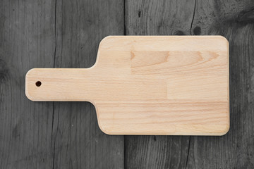 empty cutting board on dark wooden planks