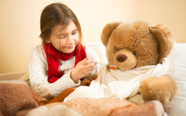 cute girl playing in hospital with teddy bear