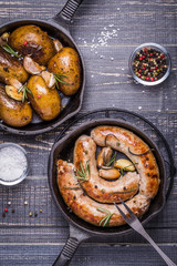 Rustic style potatoes and fried sausages