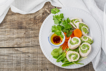 Rolls of chicken breasts and vegetables on the plate