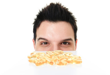 A young man is eating a omega-3 pill