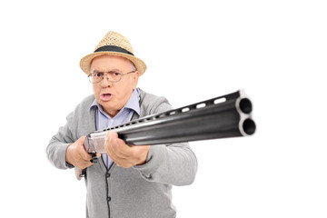 Furious senior man holding a shotgun