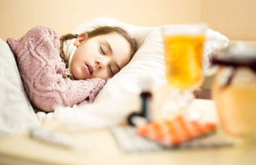 Obraz na płótnie Canvas little sick girl in sweater sleeping in bed